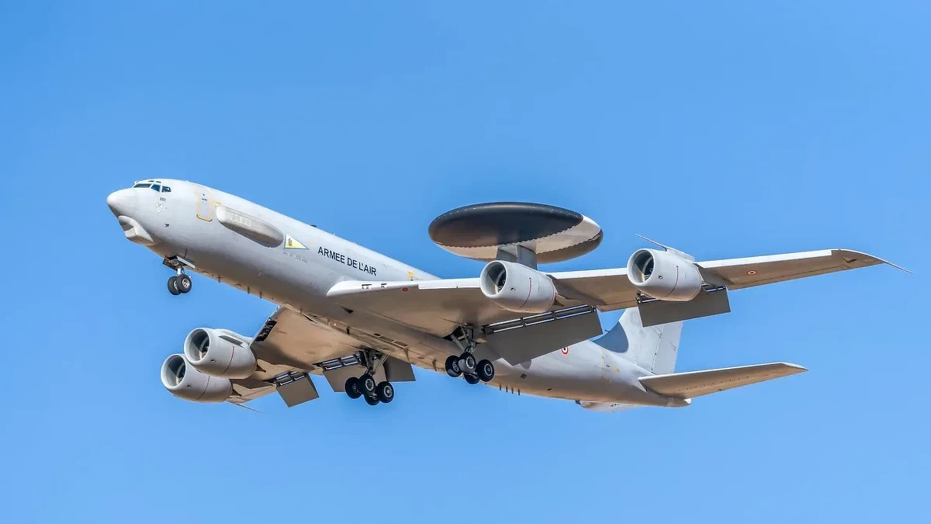 Close-up of a military radar system with a clear blue sky as background, showcasing advanced communication technology.