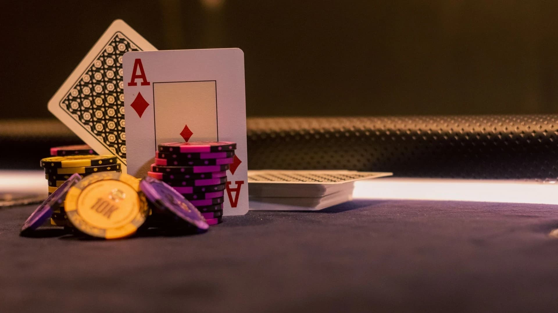 A close-up of poker chips and playing cards on a casino gaming table, highlighting Ace of Diamonds.
